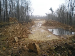 Active Mine Site with bare, dug out ground, rock piles, and steep slopes